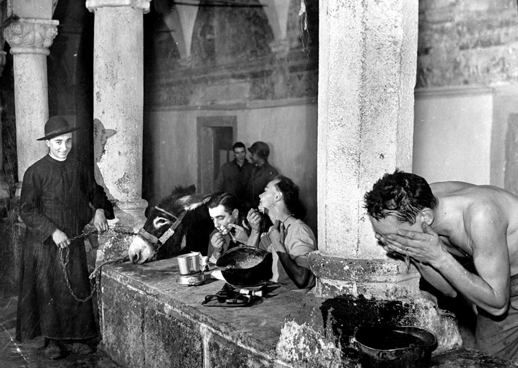 Margaret Bourke-White: Ein Priester beobachtet amerikanische Soldaten bei ihrer morgendlichen Toilette in einem mittelalterlichen Kloster Italien, Dezember 1943; Silbergelatineabzug; Howard Greenberg Gallery, New York  © Time & Life / Getty Images