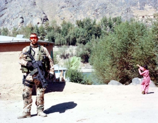 © Jo Röttger: Afghanistan, Camp Fayzabad, military policeman and playing child